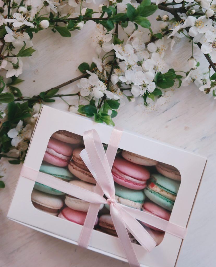 box of macarons with pink ribbon
