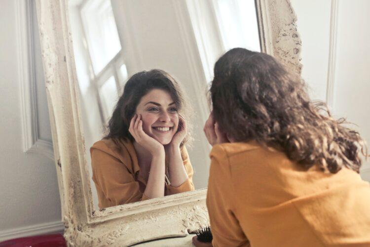 woman smiling in front of the mirror