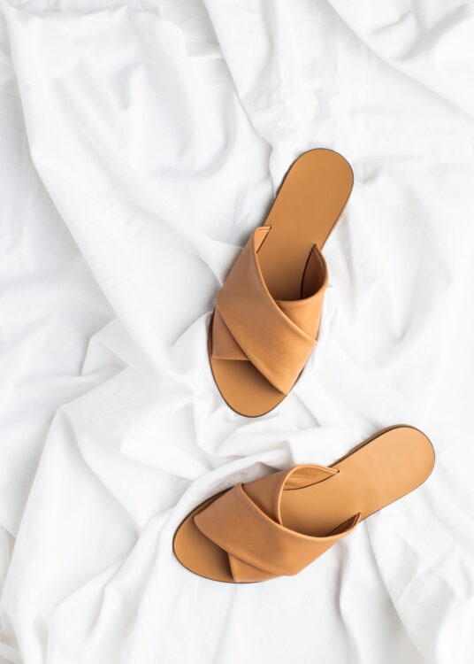 Nude sandals on a white sheet