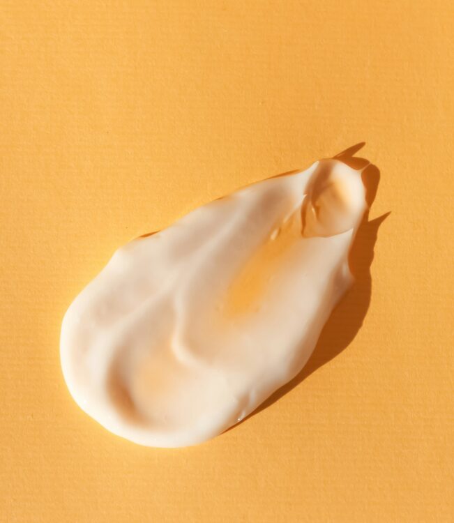 moisturizer for eczema A swipe of moisturizer against an orange background