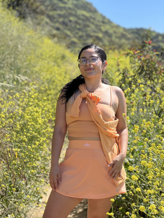 Model wears an orange matching set from Alo