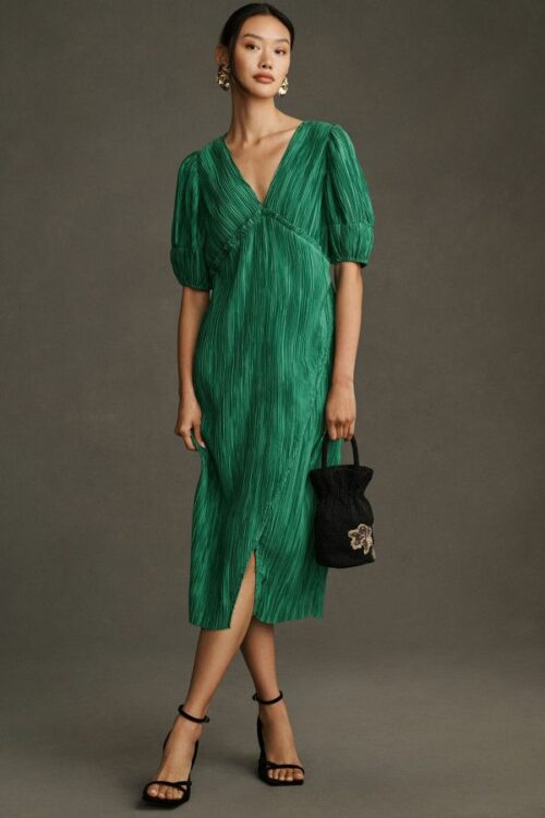 Model wears a green pleated dress, which is a great casual spring outfit idea