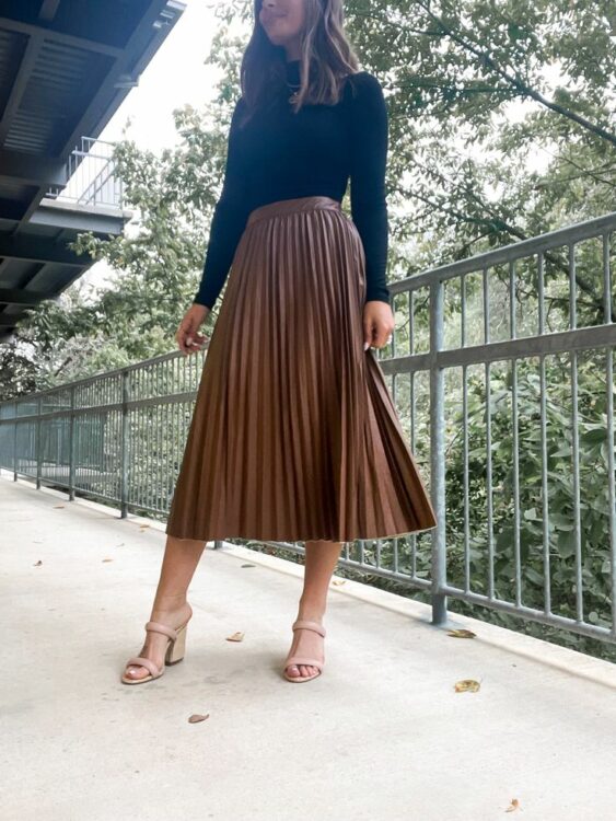 Wearing a black turtleneck with a pleated skirt