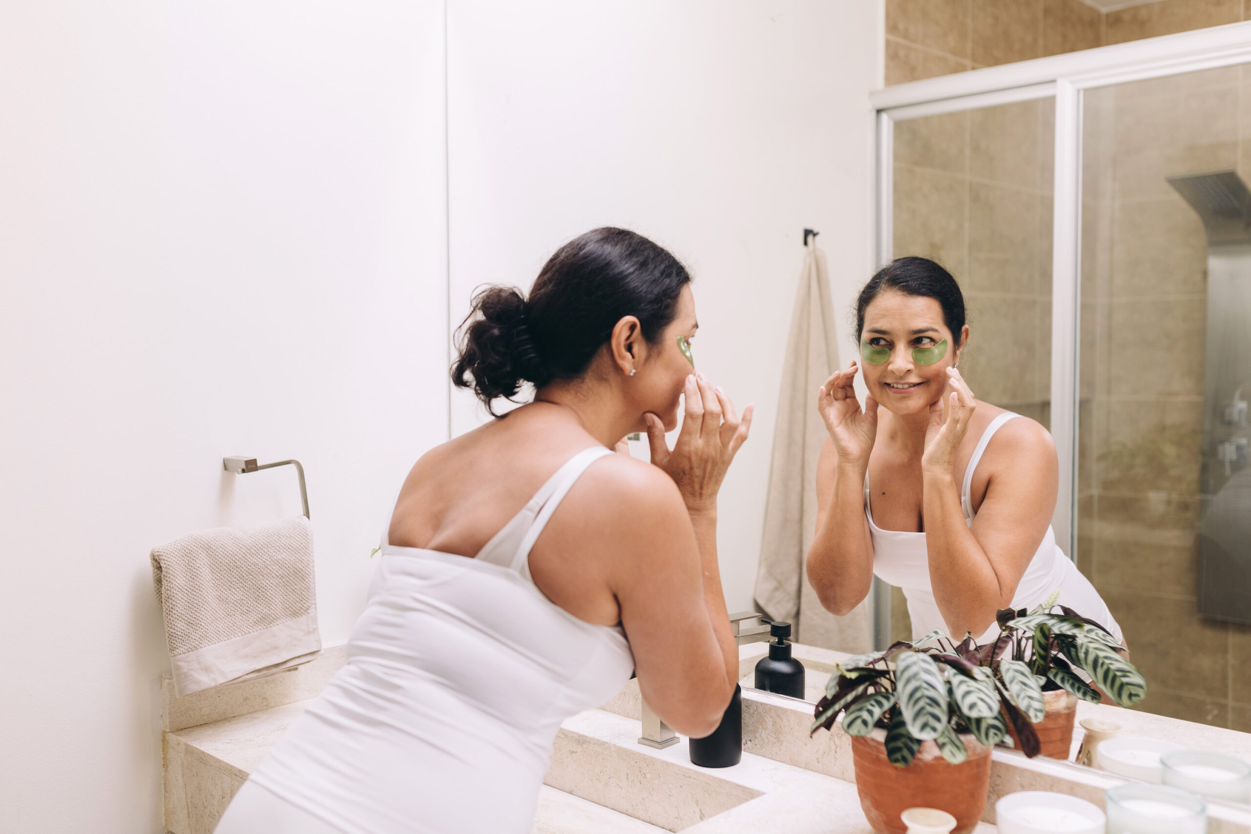 Person in mirror wearing green under-eye masks