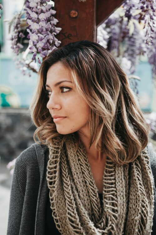 Person looking to the side wears a circle scarf, also known as an infinity scarf