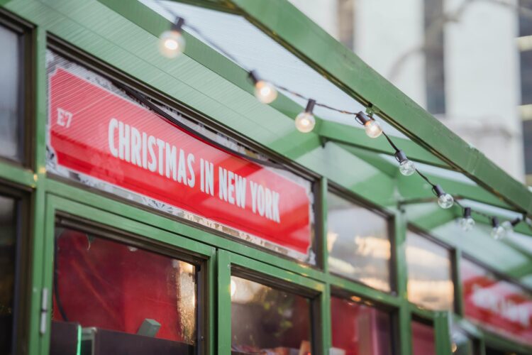 A red sign in a green building reading "Christmas in New York"