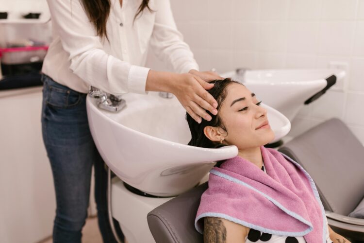 Brunette getting their hair professionally washed by a hairstylist