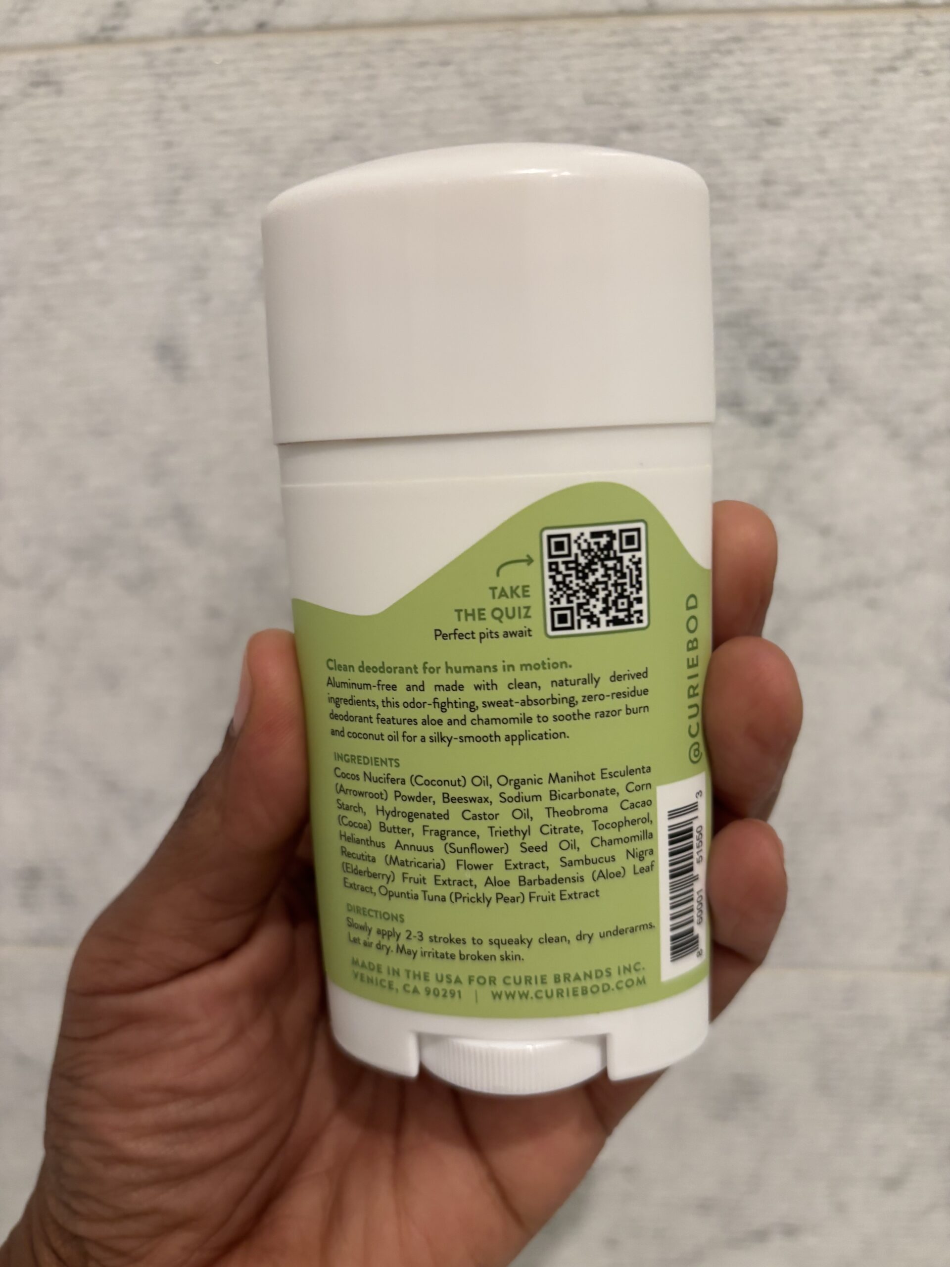 The ingredients list of a white stick of deodorant with a green label