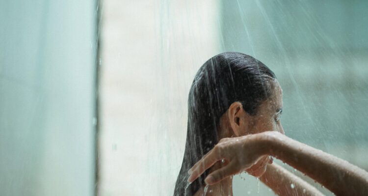 Person taking a shower with their back facing the showered