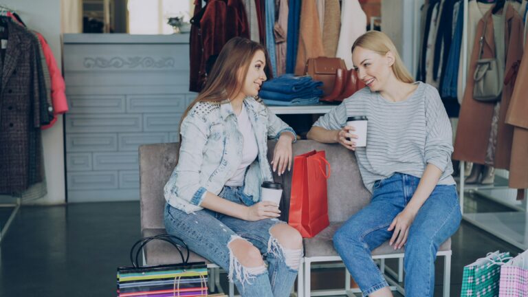 Two people sitting down while shopping and drinking coffee