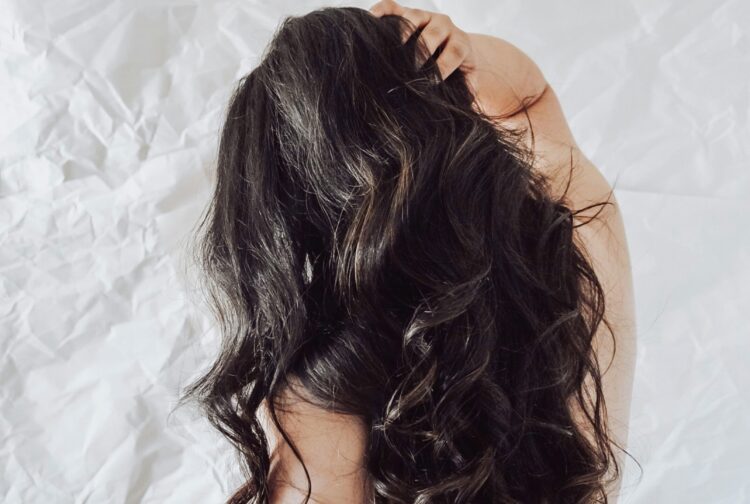Person with long black hair that's styled into loose curls